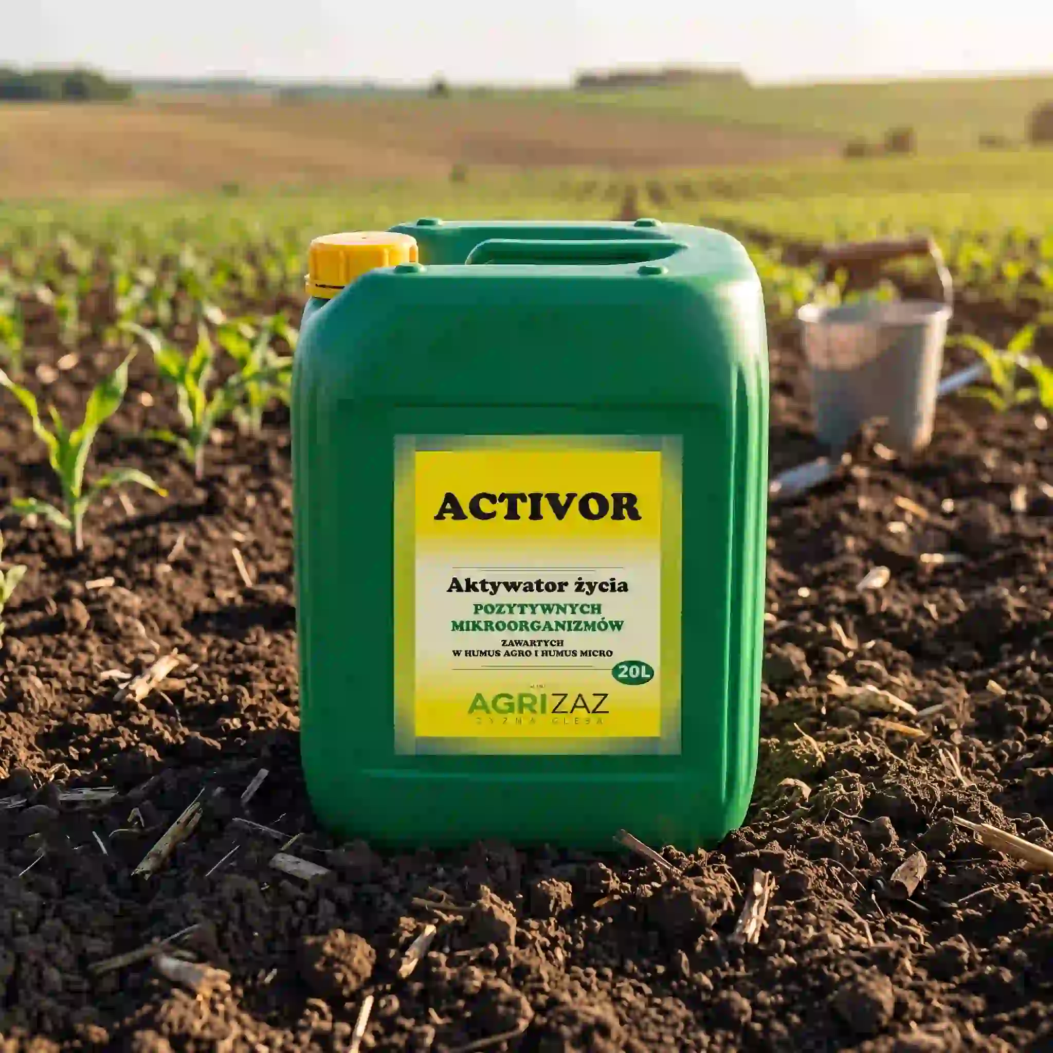 Zielony kanister 20L aktywatora mikroorganizmów Activor marki Agrizaz stojący na glebie w polu z młodymi roślinami